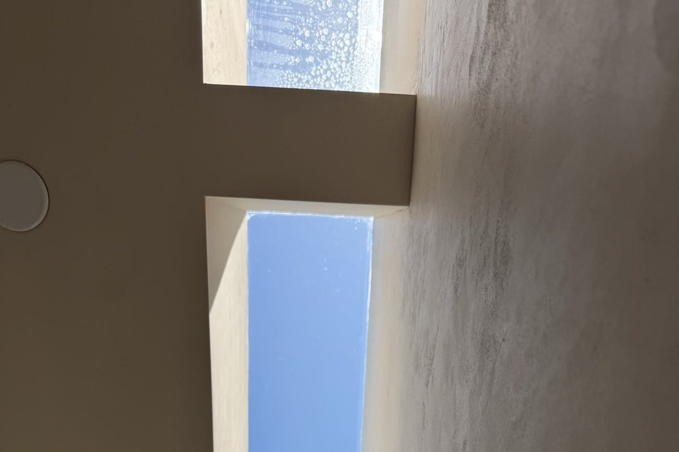 Skylight in a new build part-cleaned, one pane still soapy and the next showing clear blue sky