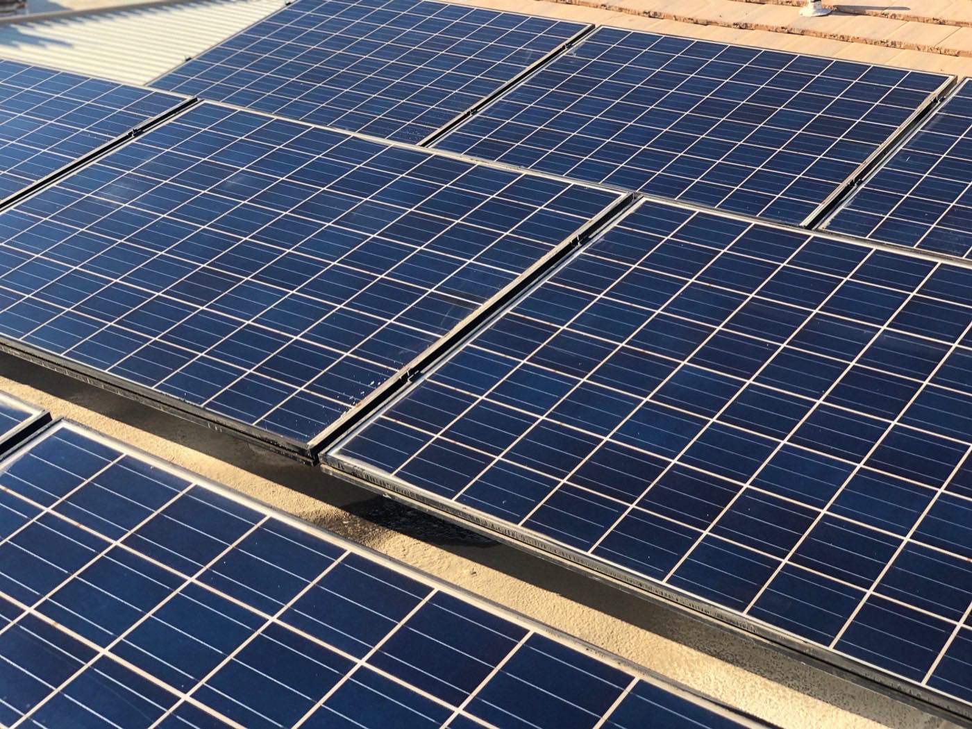 Solar panels on an Indio area rooftop being cleaned of desert dust